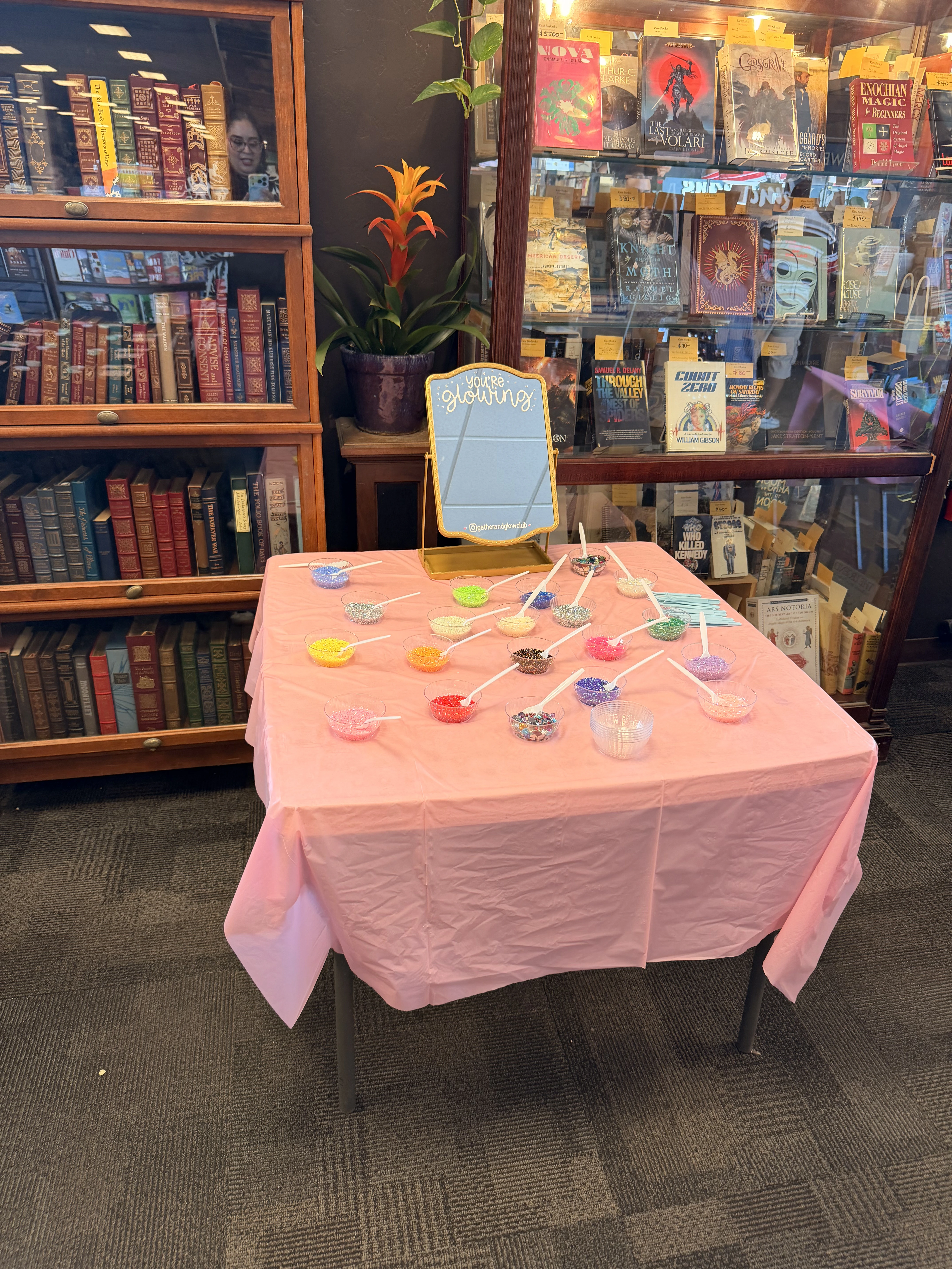 Charm bar bead table set up between bookcases at a Gather and Glow Club event